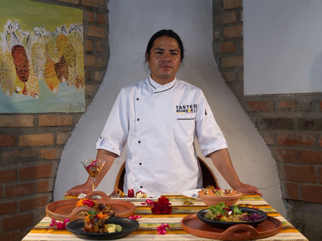 Tupay Chef Tupay's chef standing behind a selection of specialty dishes.