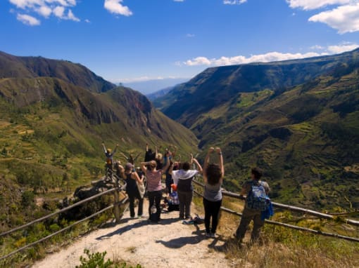 Vistas Andinas Grupo de jóvenes turistas contemplando las cadenas montañosas andinas con vistas hacia la cuenca amazónica.