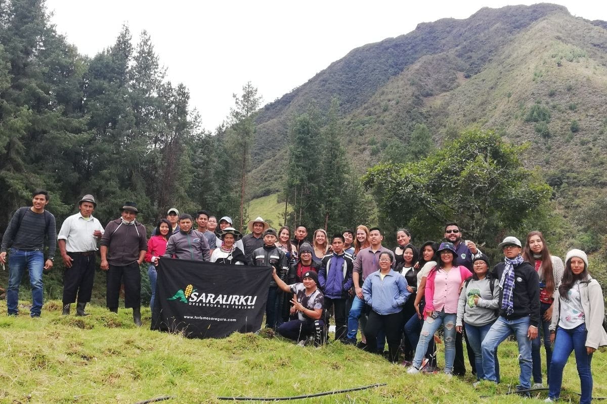 "Group of tourists visiting the indigenous community of Ilincho, in a rural Andean setting"